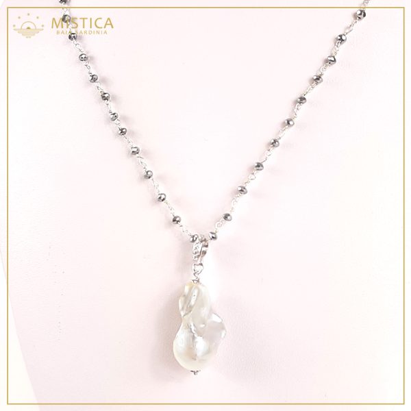 Collana a lavorazione rosario in argento 925% ed ematiti, decorata con ciondolo di perla scaramazza con contromaglia zirconata. Lunghezza massima 76cm regolabile.