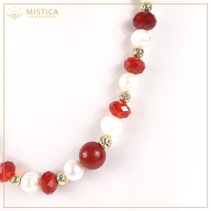 Collana di perle con sfere di cristallo rosso sfaccettato e zama, chiusura in argento 925% bagno oro. Lunghezza massima 52cm regolabile.